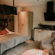 Interno di una tiny house loft di lusso con letto, angolo cottura e poltrona al Camping Si-Es-An, Paesi Bassi.