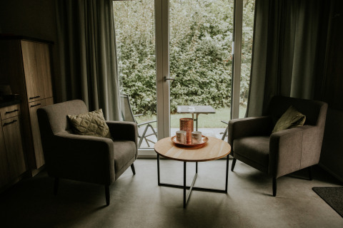 Deux fauteuils et une table ronde dans un loft de luxe tiny house au Camping Si-Es-An, Pays-Bas.