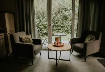 Deux fauteuils et une table ronde dans un loft de luxe tiny house au Camping Si-Es-An, Pays-Bas.