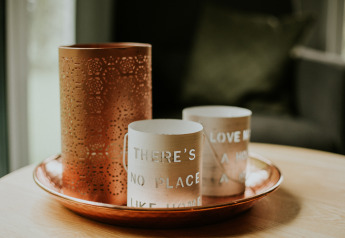 Decorative tray with copper and beige candle holders on a table in a luxury loft tiny house in the Netherlands.