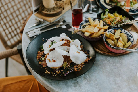 Comida de lujo en mesa redonda con papas fritas, ensalada y crujientes en Camping Si-Es-An, Países Bajos.