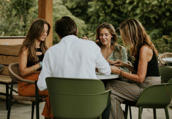 Fire personer sidder sammen og spiser ude på en terrasse ved Luxury loft, Camping Si-Es-An, Holland.