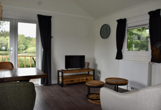 Sala de estar en Beach house con jacuzzi en Camping 't Veld, Países Bajos, vista a la naturaleza.