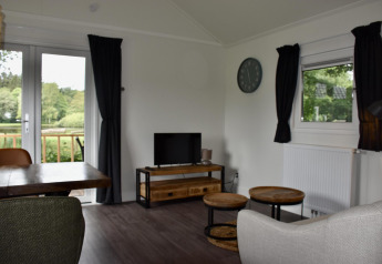 Sala de estar en Beach house con jacuzzi en Camping 't Veld, Países Bajos, vista a la naturaleza.