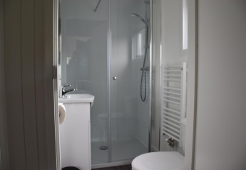 Bagno moderno con doccia, wc e lavandino nel Beach House presso Camping 't Veld, Paesi Bassi.