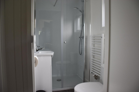 Salle de bain moderne avec douche, toilettes et lavabo au Beach House de Camping 't Veld, Pays-Bas.