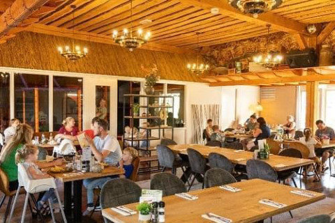 Binnen eetgedeelte van Beach house met hottub bij Camping 't Veld in Nederland, gezinnen aan tafel.