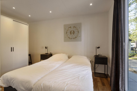 Modern bedroom with twin beds, large wardrobe, and ample daylight at Module Wood lodge in Bospark Ede.