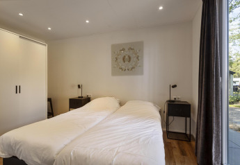 Modern bedroom with twin beds, large wardrobe, and ample daylight at Module Wood lodge in Bospark Ede.