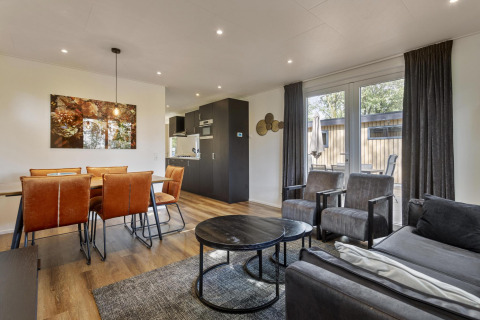 Modern stue og spiseområde i Module Wood-lodgen ved Bospark Ede, Nederlandene, med stilfuld indretning.