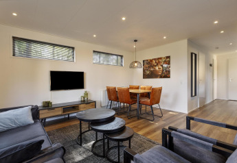Moderne woon- en eetruimte in Module Wood lodge, Bospark Ede, Nederland, met elegante inrichting.