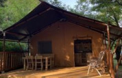 Safari telt med sanitære faciliteter på Camping Monti del Sole i Italien omgivet af grønne træer.