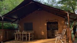 Tenda safari con servizi igienici al Camping Monti del Sole in Italia, circondata dalla natura.