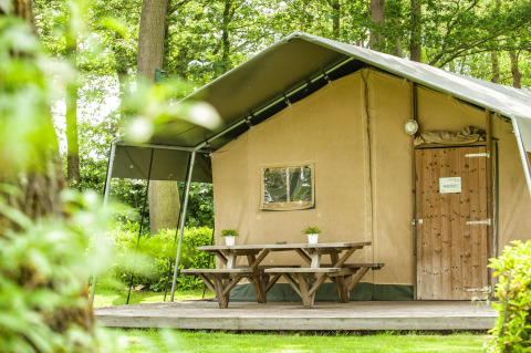 Safari-Zelt im Recreation Park Den Blanken in den Niederlanden mit Picknicktisch auf Holzterrasse.