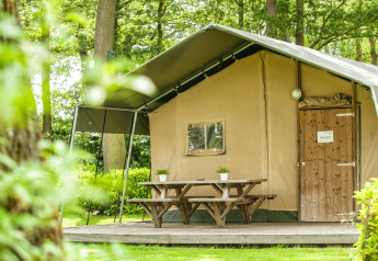 Safari-Zelt im Recreation Park Den Blanken in den Niederlanden mit Picknicktisch auf Holzterrasse.