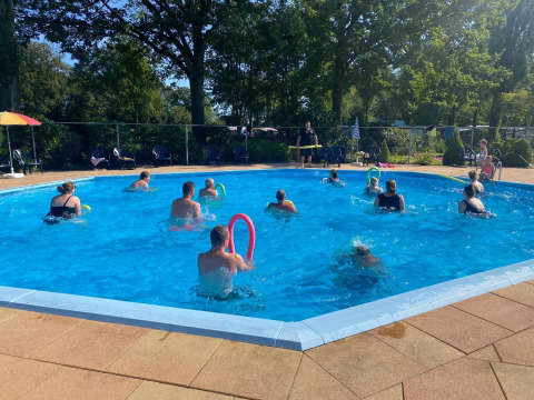 People enjoying water aerobics in a round outdoor pool at the Safari tent at Recreation Park Den Blanken, Netherlands.
