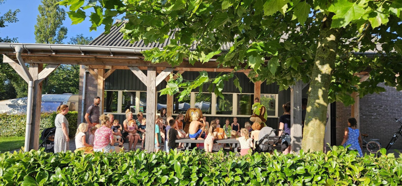 Niños y adultos se reúnen frente a una tienda safari en el Recreation Park Den Blanken en los Países Bajos.