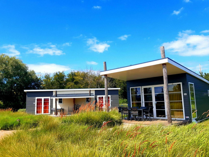 Dos casas diminutas modernas en Comfort Lodge, Kompas Camping Westende, Bélgica, rodeadas de naturaleza verde.