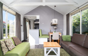 Helles, modernes Wohnzimmer in der Meine Luxe Lodge bei Tusken de Marren, Niederlande, mit großen Fenstern.