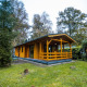 Cabaña de madera Wellness Lodge en Buitencentrum Hessenheem, Países Bajos, rodeada de bosque.