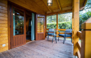 Acogedora terraza de madera en la wellness lodge de Buitencentrum Hessenheem, Países Bajos, con asientos.