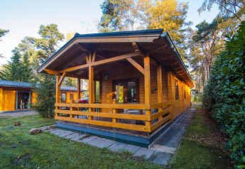 Wellness lodge ved Buitencentrum Hessenheem i Holland, omgivet af skov og natur, træveranda foran.