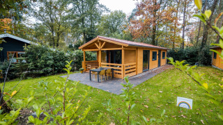 Lodge wellness en Buitencentrum Hessenheem, Países Bajos, cabaña de madera rodeada de naturaleza y paz.