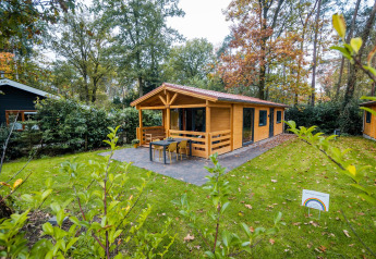 Wellness lodge at Buitencentrum Hessenheem in the Netherlands, cozy wooden cabin surrounded by greenery.