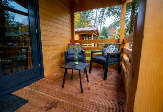 Veranda accogliente al Wellness Lodge presso Buitencentrum Hessenheem, Paesi Bassi, con sedie e tavolo.