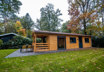 Jolie lodge bien-être au Buitencentrum Hessenheem, aux Pays-Bas, entourée d’arbres et de verdure.