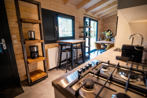 Cocina moderna y comedor en el interior de una cabaña Wellness Lodge en Buitencentrum Hessenheem, Países Bajos.