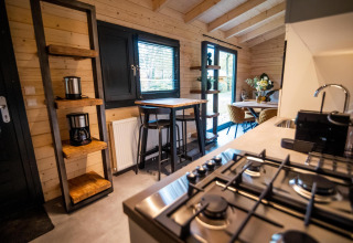 Cocina moderna y comedor en el interior de una cabaña Wellness Lodge en Buitencentrum Hessenheem, Países Bajos.