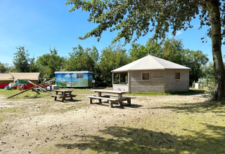 Zicht op het Dune house bij Marina Parcs Almere in Nederland, met picknicktafels en natuur rondom.