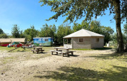View of Dune house at Marina Parcs Almere, Netherlands, with picnic tables and lush surroundings.