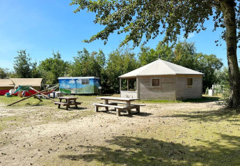 View of Dune house at Marina Parcs Almere, Netherlands, with picnic tables and lush surroundings.