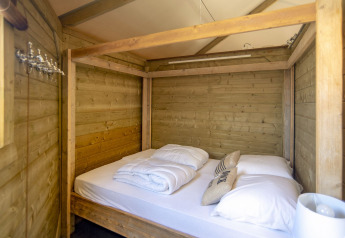 Slaapkamer met houten wanden en hemelbed in Dune house bij Marina Parcs Almere, Nederland, knusse sfeer.