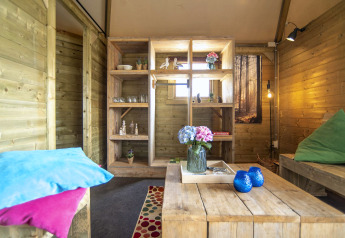 Cozy interior of Dune house lodge at Marina Parcs Almere, Netherlands, with wood decor and floral accents.