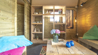 Acogedor interior de la Dune house en Marina Parcs Almere, Países Bajos, con decoración de madera y flores.