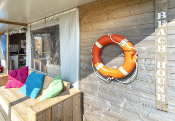 Zona relax esterna della Dune house a Marina Parcs Almere, Paesi Bassi, con salvagente e cuscini colorati.