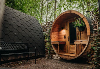 Foto esterna della tiny house Boshuys Ultra Wellness con facciata in legno al Buitengoed Ruysbos, Paesi Bassi.