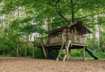 Casa sull’albero al Boshuys Ultra Wellness, Buitengoed Ruysbos, Paesi Bassi, immersa nel verde.
