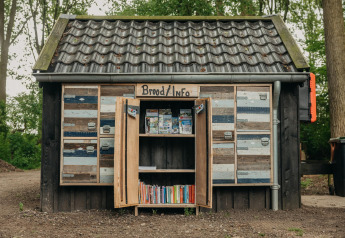 Pequeña casa de madera con letrero 'Brood/Info', en el bosque de Buitengoed Ruysbos, Países Bajos.