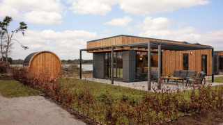 Modern holiday villa Amalia 6 with sauna at Hofparken De Bergvennen in the Netherlands, terrace and lake view.