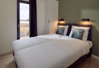 Modern bedroom in Holiday villa Amalia 6 + sauna at Hofparken De Bergvennen, featuring two single beds.