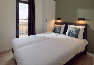 Dormitorio moderno en Holiday villa Amalia 6 + sauna en Hofparken De Bergvennen, con dos camas individuales.