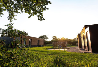Villas vacacionales modernas al atardecer entre zonas verdes en Hofparken De Bergvennen, Países Bajos.