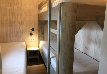 Kamer met stapelbed en eenpersoonsbed in de Safarilodge-tent op Camping de Noetselerberg, Nederland.
