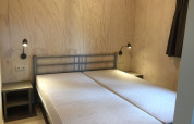 Bedroom in a Safarilodge tent at Camping the Noetselerberg, Netherlands, featuring two twin beds.