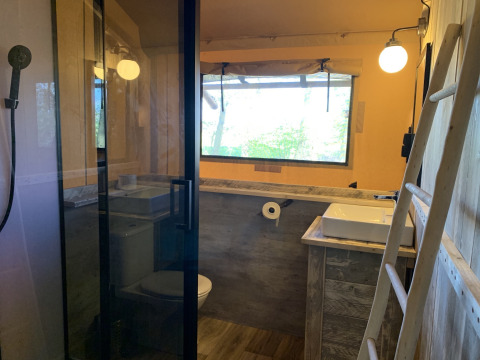 Salle de bain d'une tente safari au Glamphuys, Buitengoed Ruysbos, Pays-Bas, avec style bois moderne.
