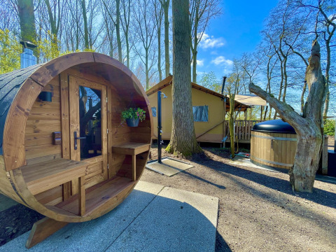 Zona de bienestar al aire libre en la tienda safari Glamphuys Ultra Wellness con sauna y jacuzzi en Buitengoed Ruysbos.